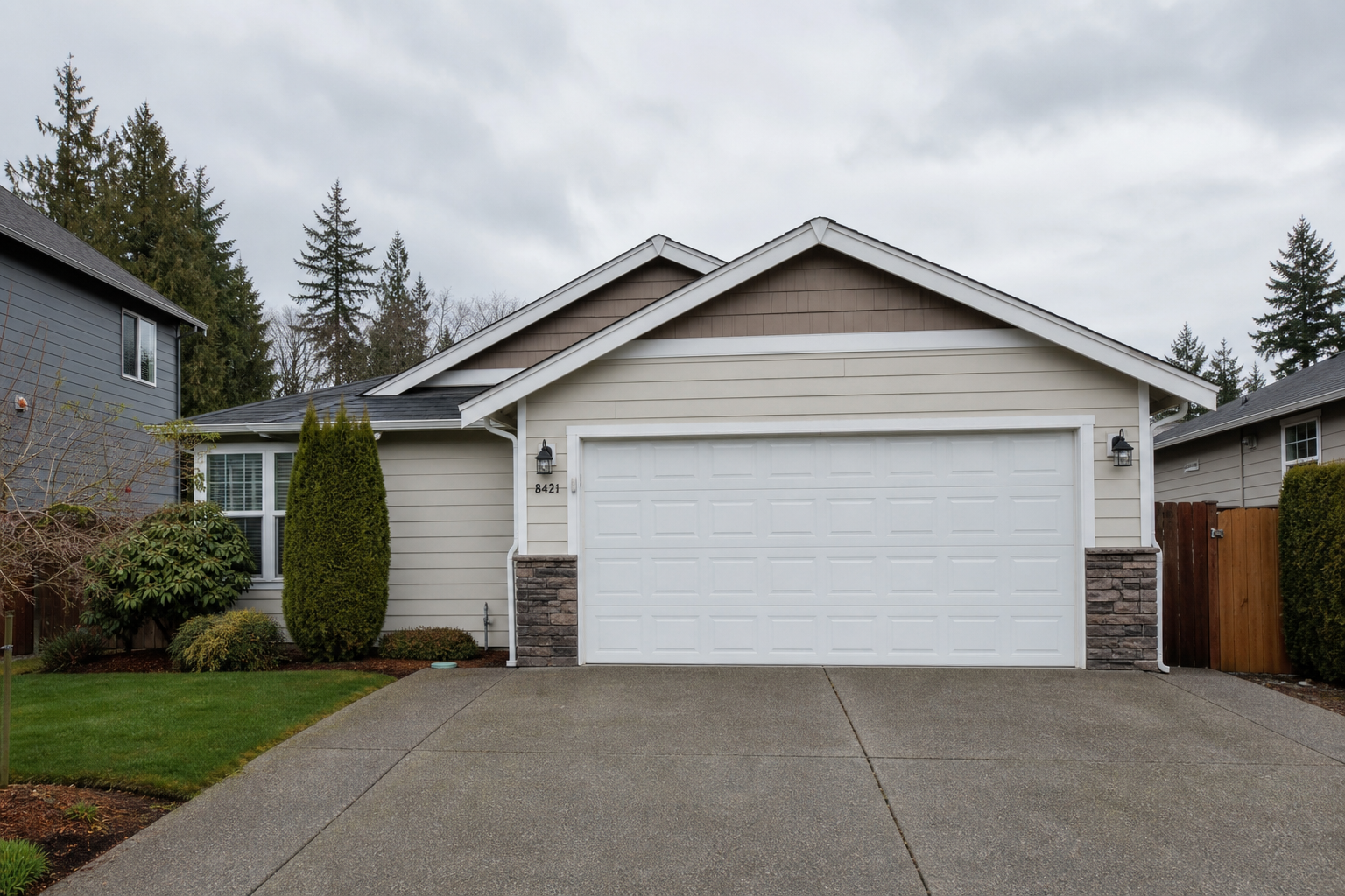 Tacoma home exterior with a closed insulated garage door on a quiet residential driveway